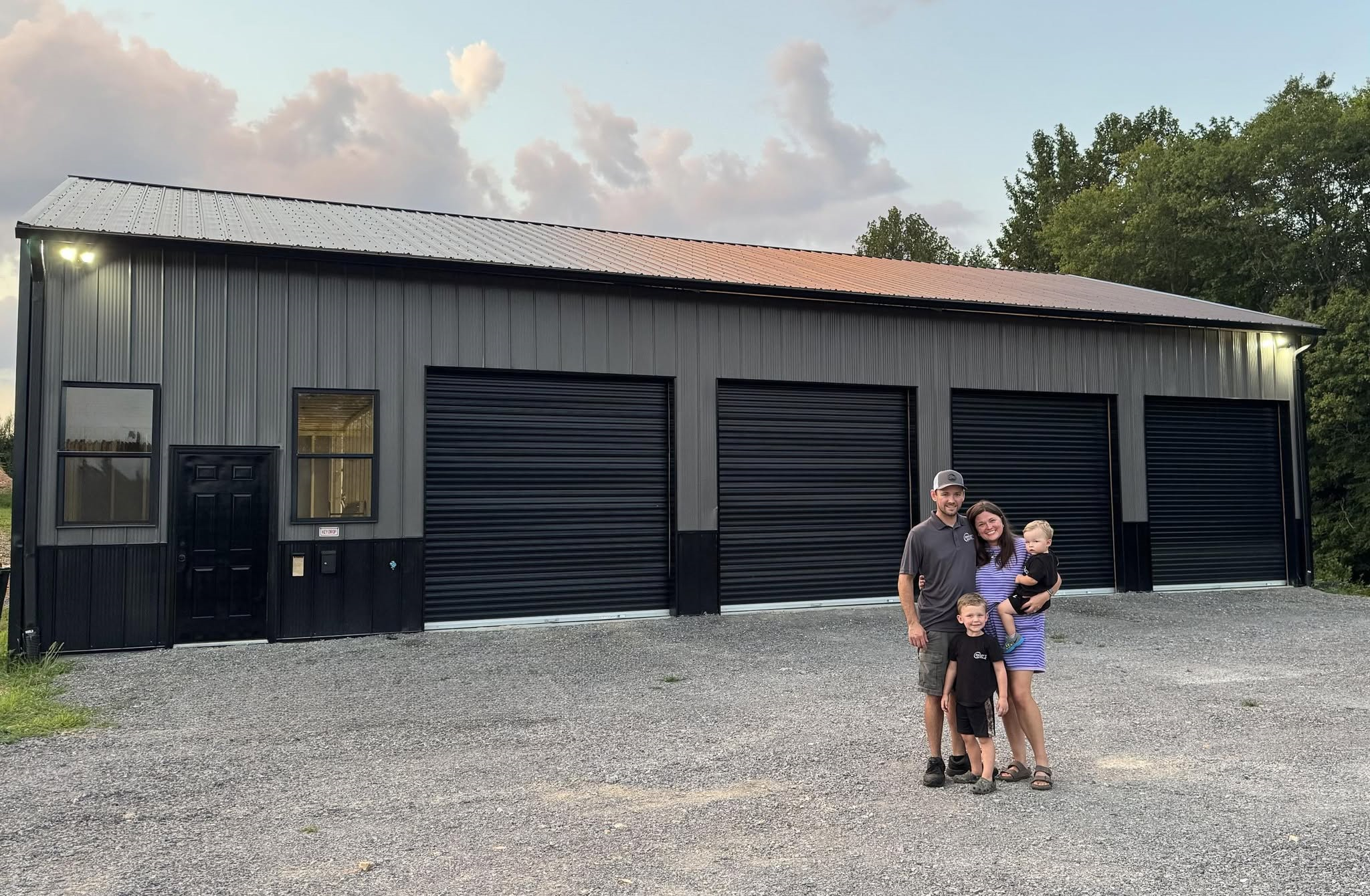 A photo of the outside of the shop featuring four bay doors along with the Dailey family